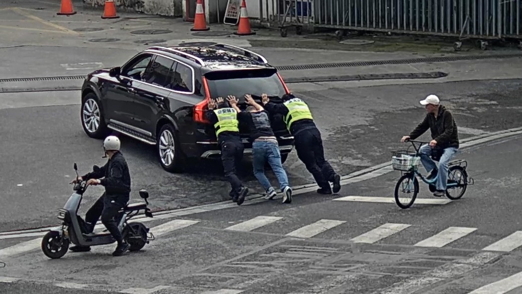 開到半路車沒油了，好在輔警“給力”，四人徒手推進加油站