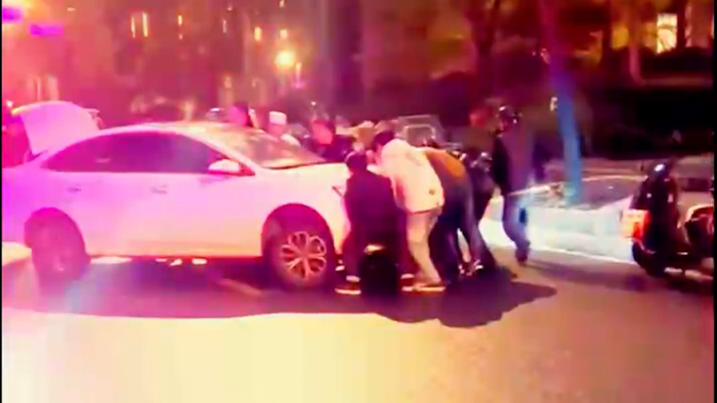電瓶車司機被卷入車底，上海黃浦警民聯手抬車救出