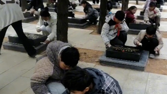 清明节前夕，小学生为烈士墓碑擦灰