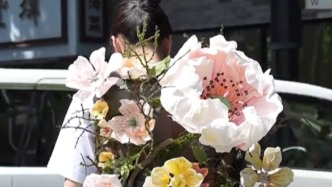 90后滬上青年藝術家自制仿真花卉裝置，將“春天”背在身上