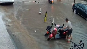 暴雨來襲，房東冒雨幫租戶轉移積水中的電動車