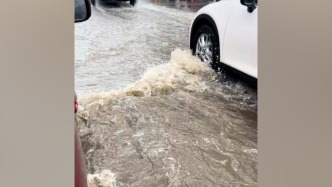 武汉市气象台发布暴雨红色预警信号，部分路段积水车辆蹚水行驶