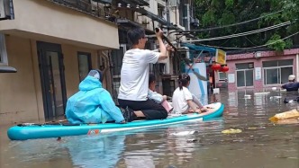 武漢暴雨過后，家長劃皮艇當“擺渡人”護送多名學生過積水