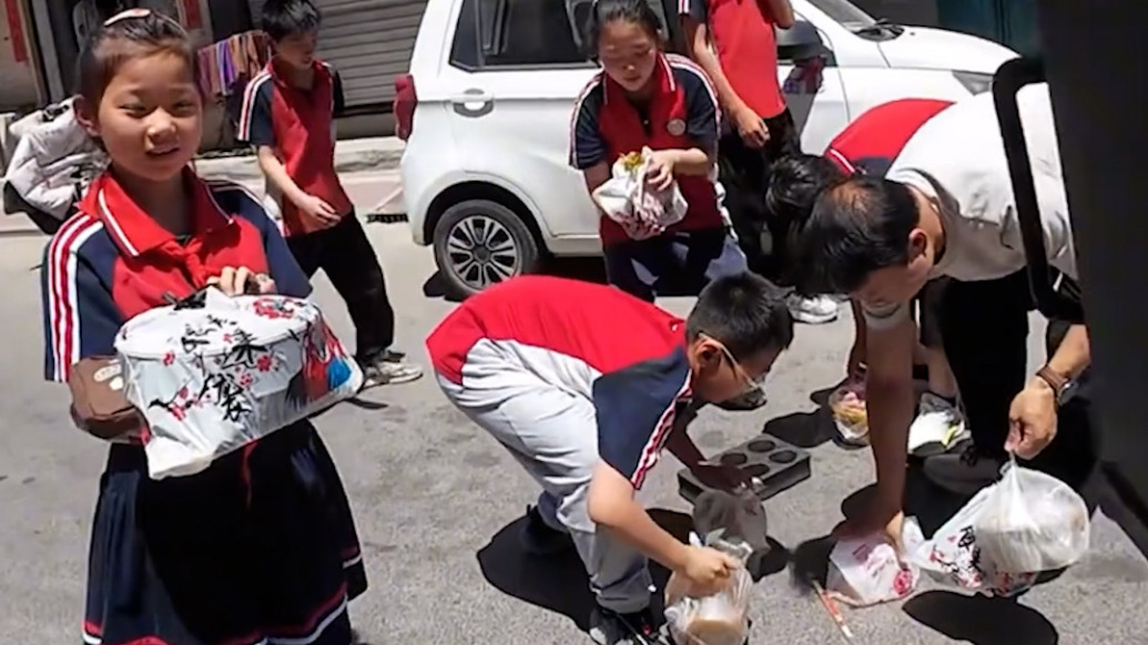 外賣小哥送餐時摔倒,一群小學生沖過來幫扶車