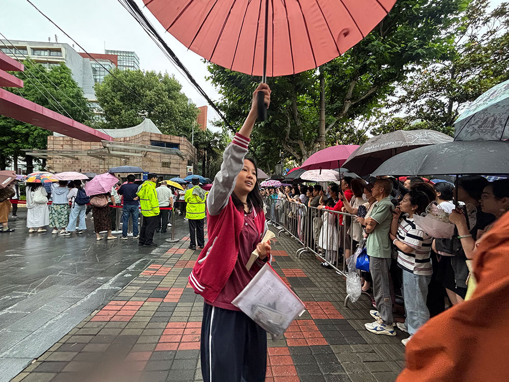 家长细雨中手捧鲜花等待，上海考生希望“外语二刷考到更理想的分数”