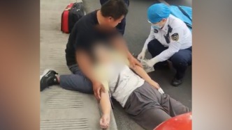 骑车女子发病瘫软，好心人半跪在地托住头部