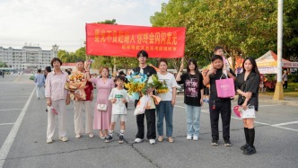 高考最后一场结束，一考生一家九口人到场打横幅祝贺