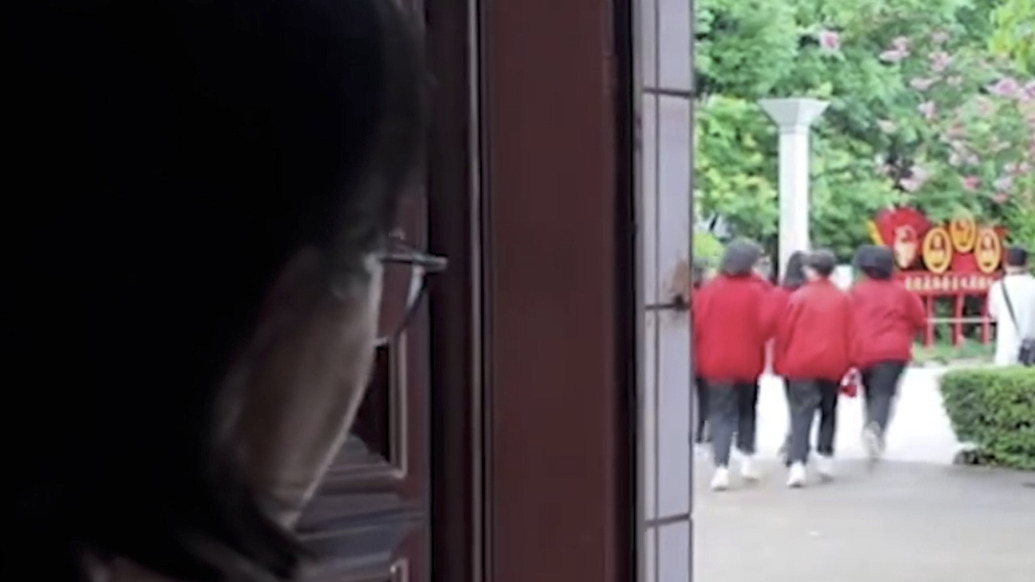 高考后張桂梅又一次躲到門后，悄悄目送畢業(yè)生離開(kāi)