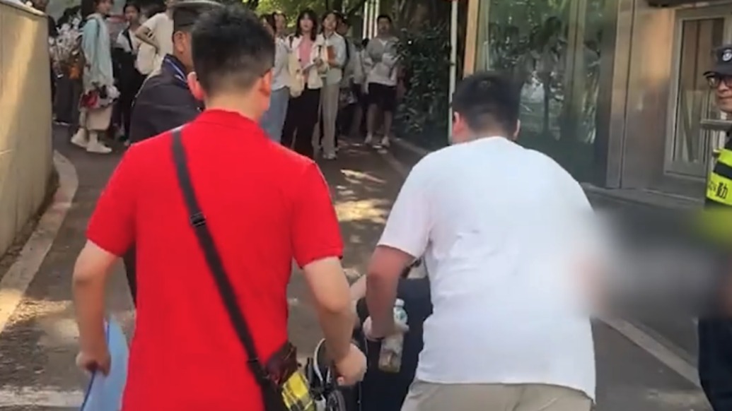 重庆一考生坐轮椅奔赴考场，同学主动帮忙