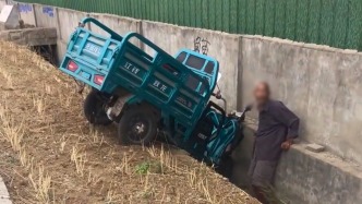 老人將三輪車開進溝里，多名路人伸出援手