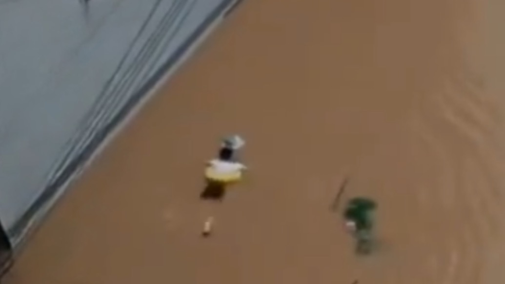 湖南龍山縣暴雨致街區(qū)積水，一中考生因暴雨帶救生圈蹚水趕考