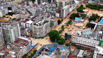 航拍广东怀集洪水退后场景：河水浑浊，志愿者、市民在街头清淤