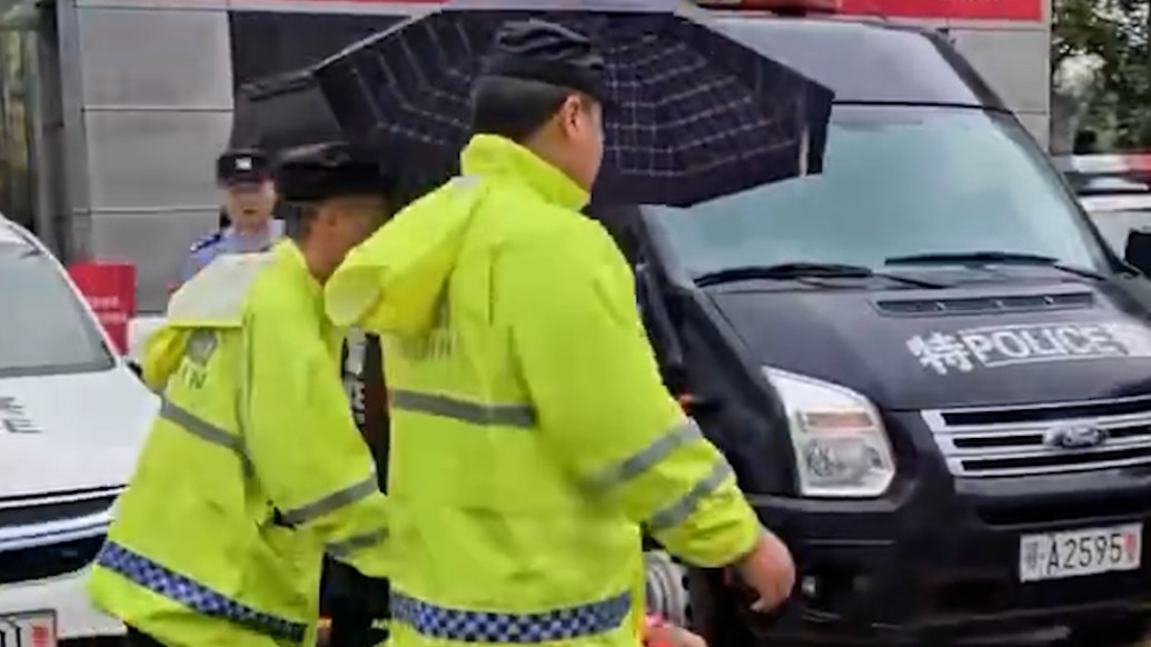 民警護(hù)送腿部受傷中考生進(jìn)考場，一路為他們加油打氣