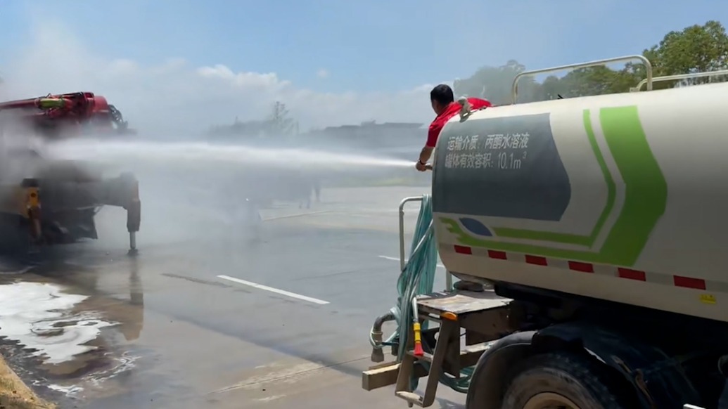 混凝土车停靠路边突发起火,洒水车喷水压制