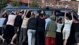 私家車意外側(cè)翻兩人被困，眾人合力抬車營救