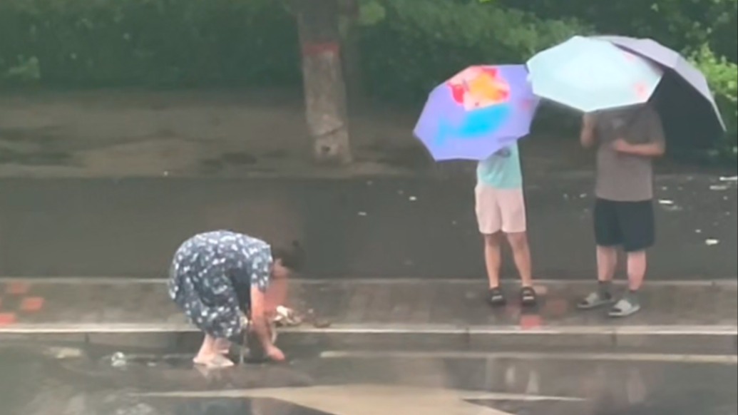 道路积水大姐弯腰清理下水道口,目击者:这份善良和担当很珍贵