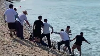 游客不慎被海浪卷入海中，眾人手拉手搭出“生命繩”