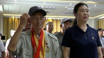 當(dāng)國歌響起，電視機(jī)前的抗戰(zhàn)老兵起身向國旗敬禮