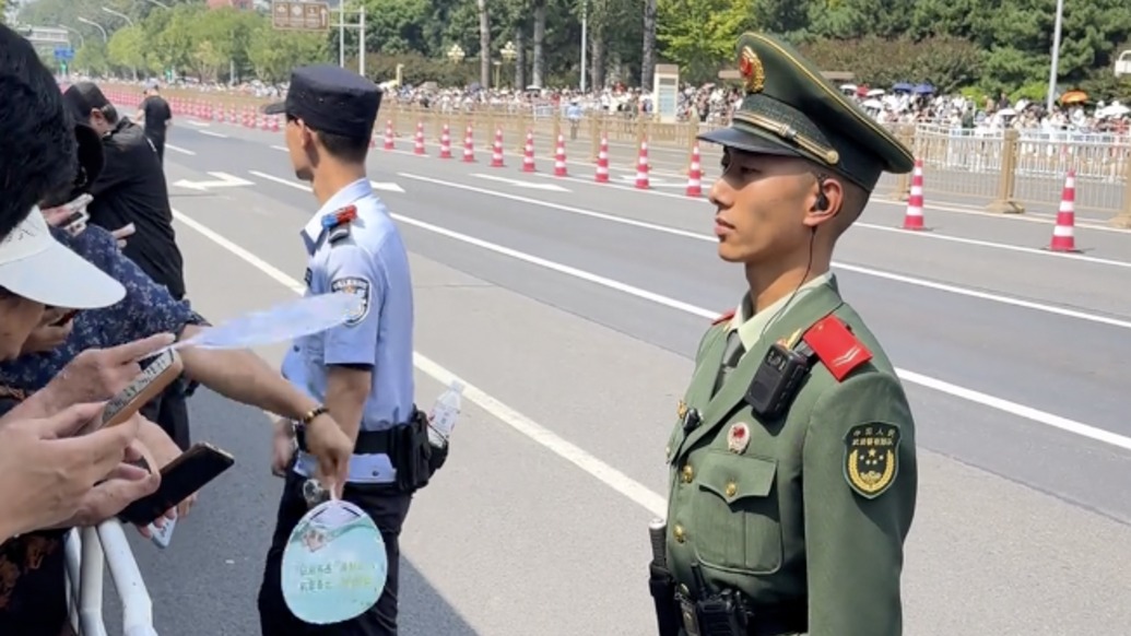 “人民与子弟兵间最真的情感”，阅兵日执勤军人纹丝不动一旁民众心疼地帮忙扇风
