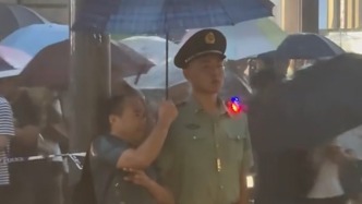 軍民一家親在此刻具象：武警戰(zhàn)士執(zhí)勤時突降大雨，群眾自發(fā)為他們撐傘