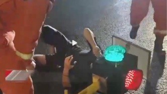 成都一男子邊騎車邊玩手機(jī)撞上燈柱，導(dǎo)致腦袋卡進(jìn)紅綠燈