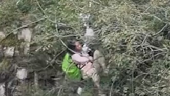 腳下就是萬丈深壑，女子跌落懸崖死死抓住樹枝，路人合力擰繩救人