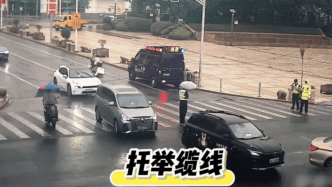 早高峰時(shí)電線垂落在路口中央，民警雨中撐舉了近三小時(shí)