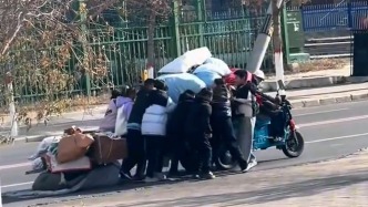 收廢品大爺?shù)碾妱榆嚊]電了，一群學生主動幫推車