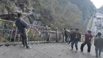 实探天门山越野车撞坏护栏处：临时用铁栏杆围挡，不少游客驻足拍照