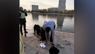 女子不慎落水，路過小伙下水施救，岸邊群眾趕來幫忙