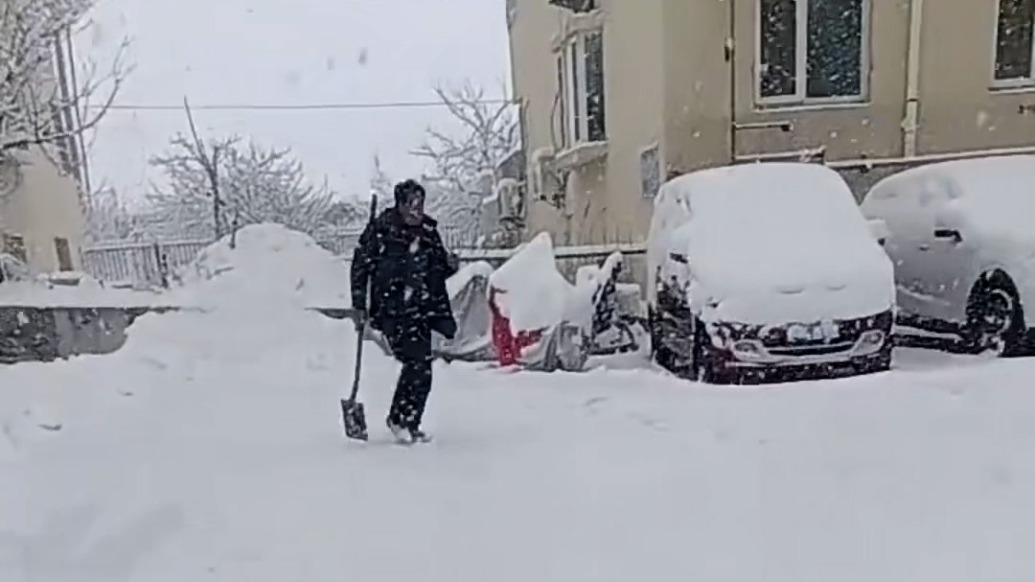 男子雪天开车爬坡“进退两难”，路过大哥雪中送“沙”