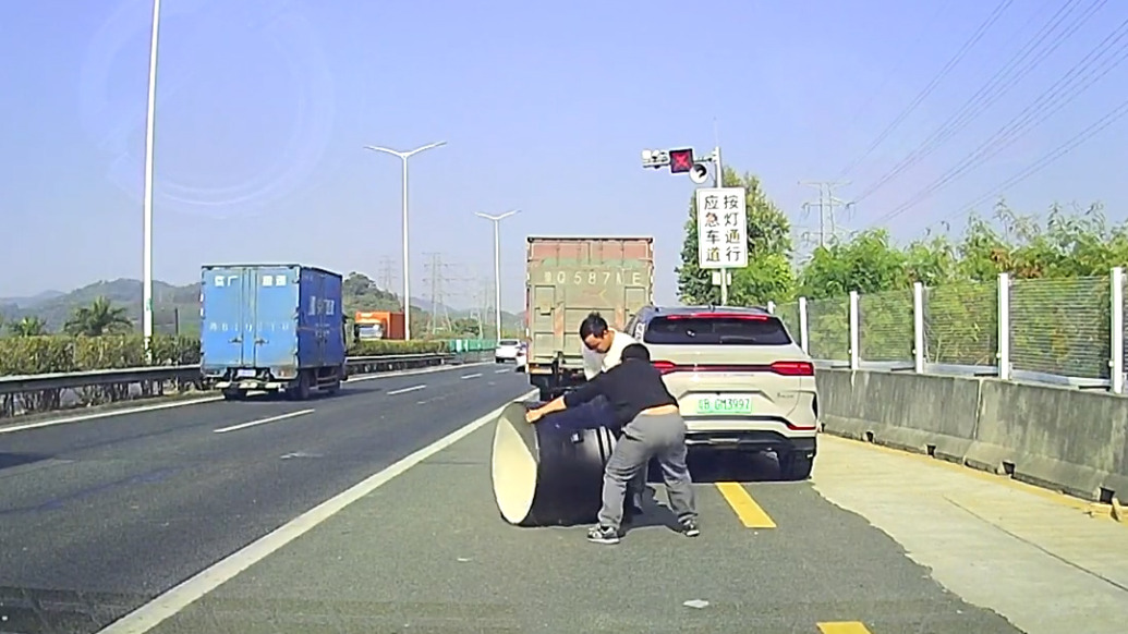 高速上有障礙物堵車,兩位熱心司機合力搬運移走