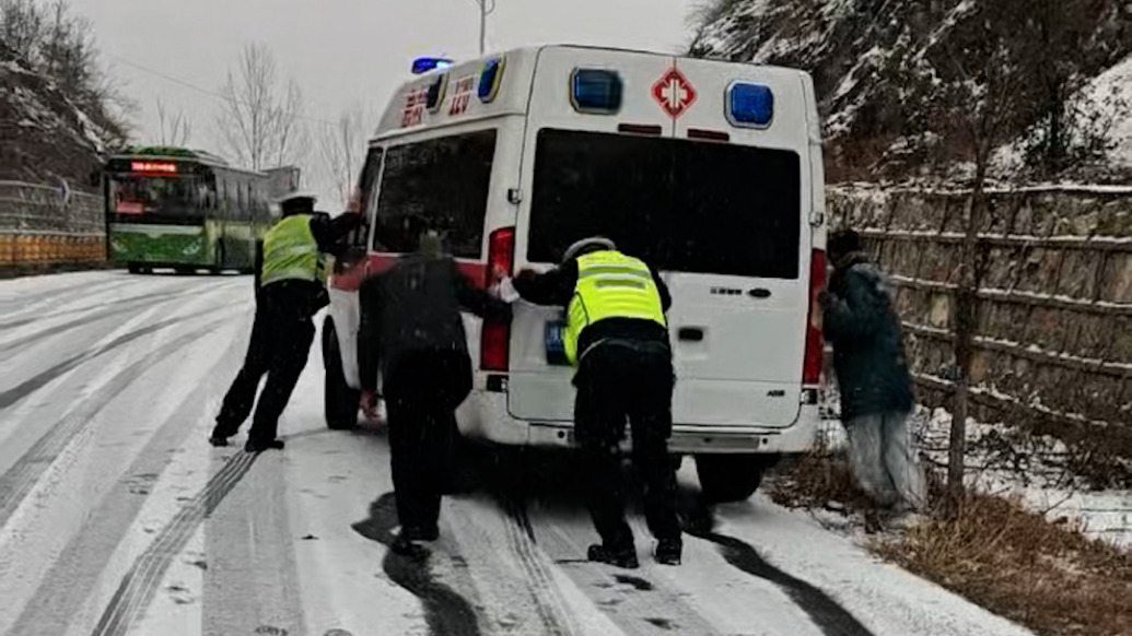 救護(hù)車原地打滑，交警踏雪推車幫助脫困