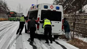 救護車原地打滑，交警踏雪推車幫助脫困