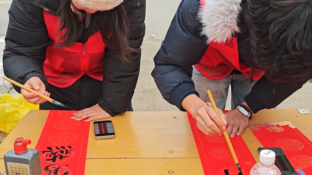 書法專業(yè)學(xué)生為社區(qū)群眾義寫春聯(lián)：鍛煉自己，貢獻青春力量 