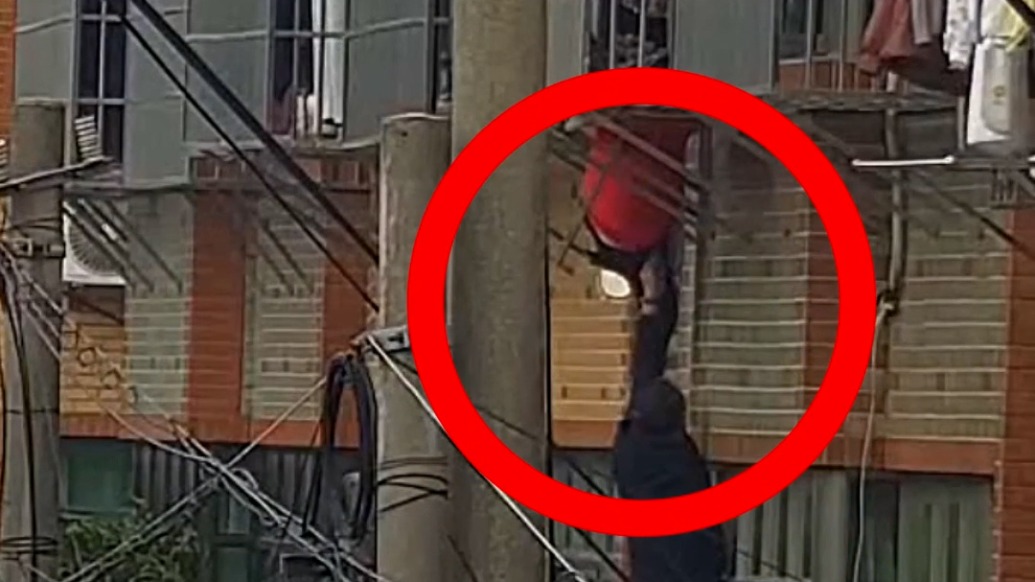 女子卡防盗窗双脚悬空，被周围邻居接力救下