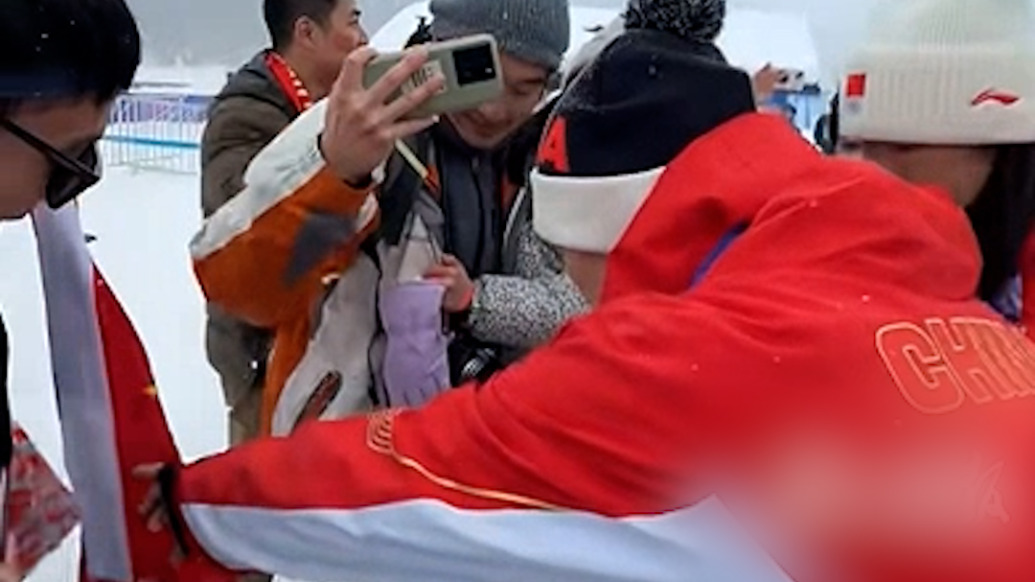 “奧運(yùn)金牌夫婦”米蘭冬奧會(huì)賽后與觀眾合影，王心迪提示別踩到國旗