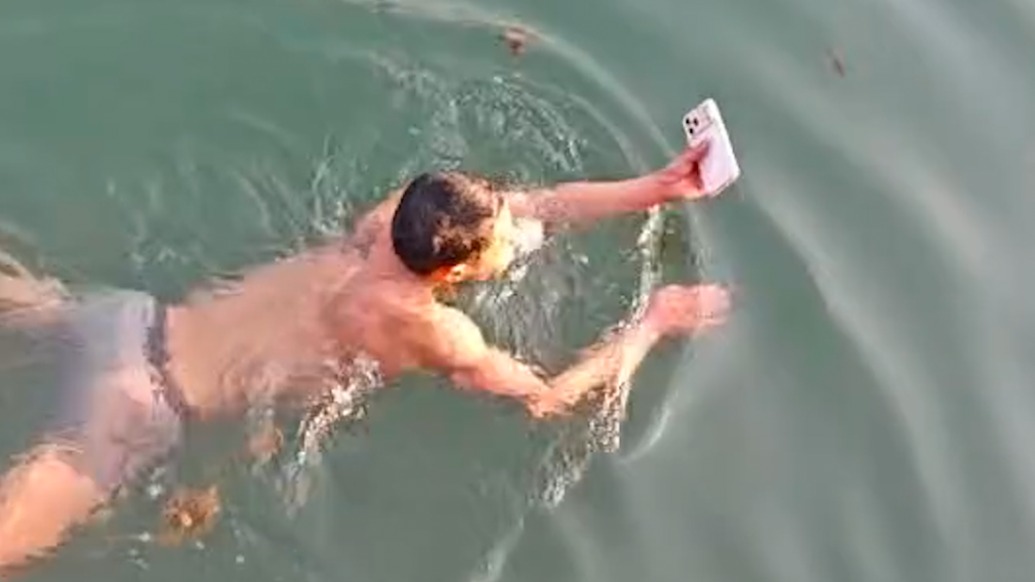 游客拍照時手機(jī)落水，景區(qū)安全員下水幫打撈岸邊響起歡呼聲