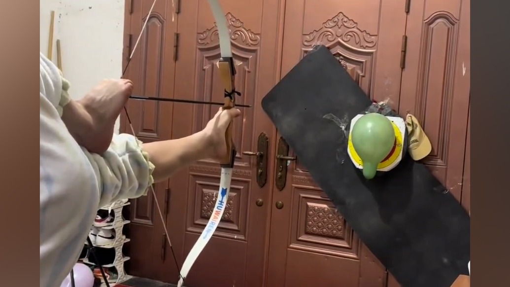 倒立射箭，杂技演员用腿开弓精准命中目标