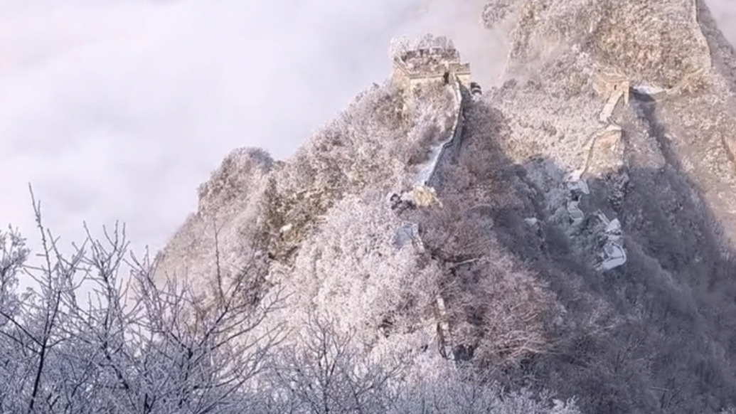 春雪覆長(zhǎng)城，游客乘纜車穿行如入畫境