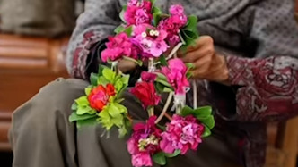 广西阳朔辟谣“89岁卖花环老人无儿无女生活孤苦”：日常由子女悉心赡养照料，售卖手工花环系个人自愿选择