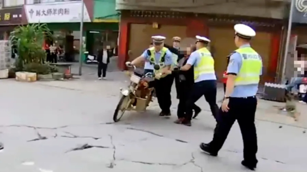 无证开无牌车被查，老人拒不认错挥拳打交警被行拘