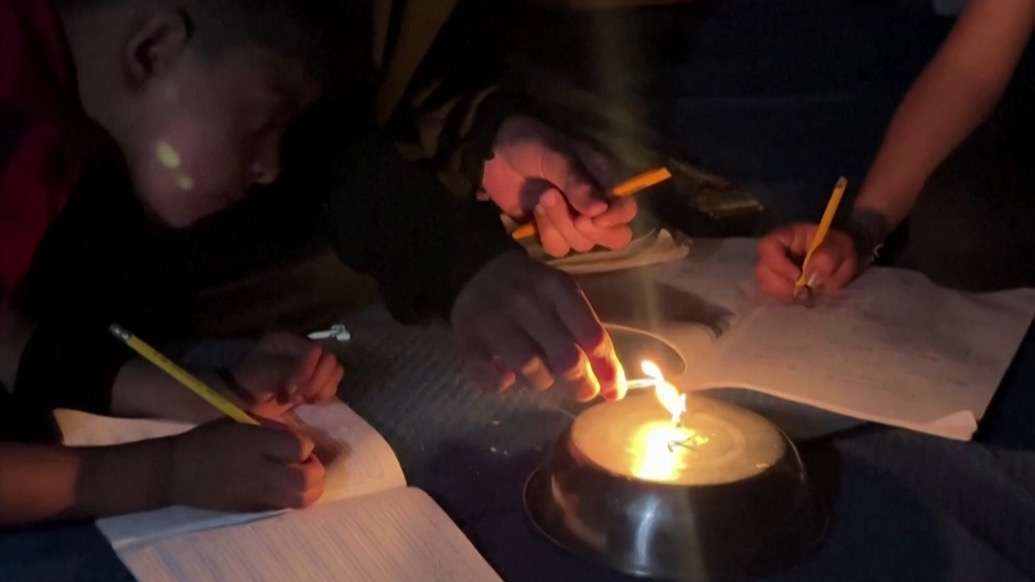 基建癱瘓電力短缺，加沙學(xué)生借燭光艱難夜讀