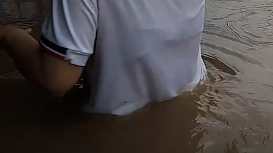 湖北安陸遇極端強降雨市民在齊腰深水中行走，當?shù)貑油９ね．a(chǎn)停業(yè)停運停課措施
