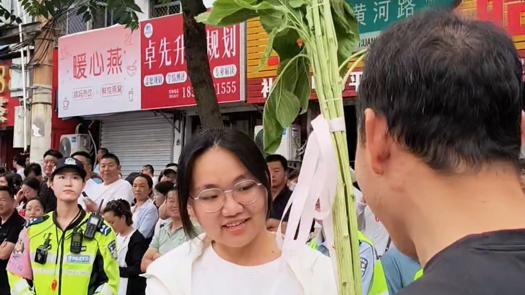 专属祝福！家长高考考点外扛着亲手种的向日葵送考