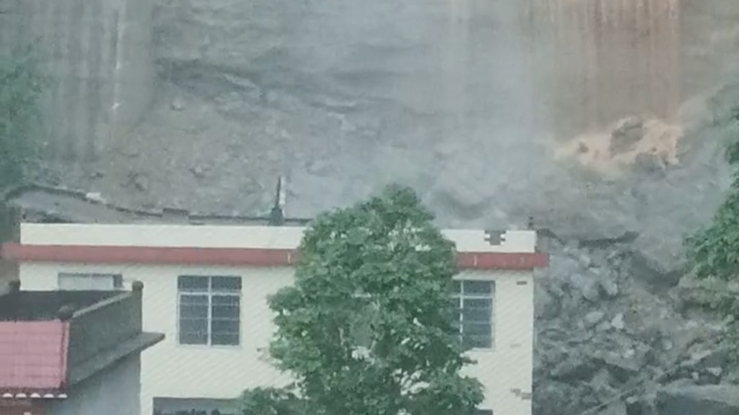 受强降雨影响广西东兰县一处民房后侧边坡滑坡,1人被困2人受伤救援正进行