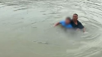 男孩捡河中竹竿落水，黑衣大哥跳入水中救起