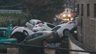 山西吕梁一路口因暴雨致多辆私家车堆叠，道路严重堵塞，不少人来寻车
