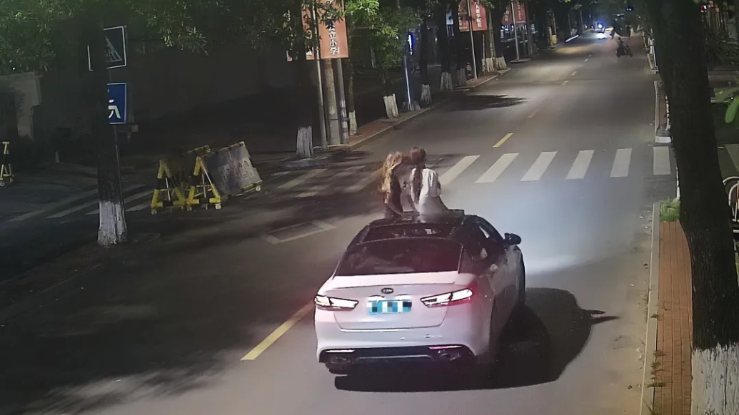 广西灵山一轿车行驶中乘客将身体探出天窗，交警传唤驾驶人
