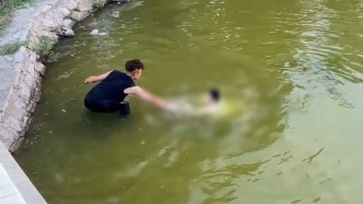 男孩不慎落水仅露一只手在水面，遛娃男子来不及脱鞋直接跳水救人
